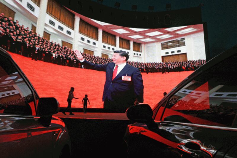 Children play near a screen showing images of Chinese President Xi Jinping in Kashgar, in northwestern China's Xinjiang region, June 1, 2019. Credit: AFP.