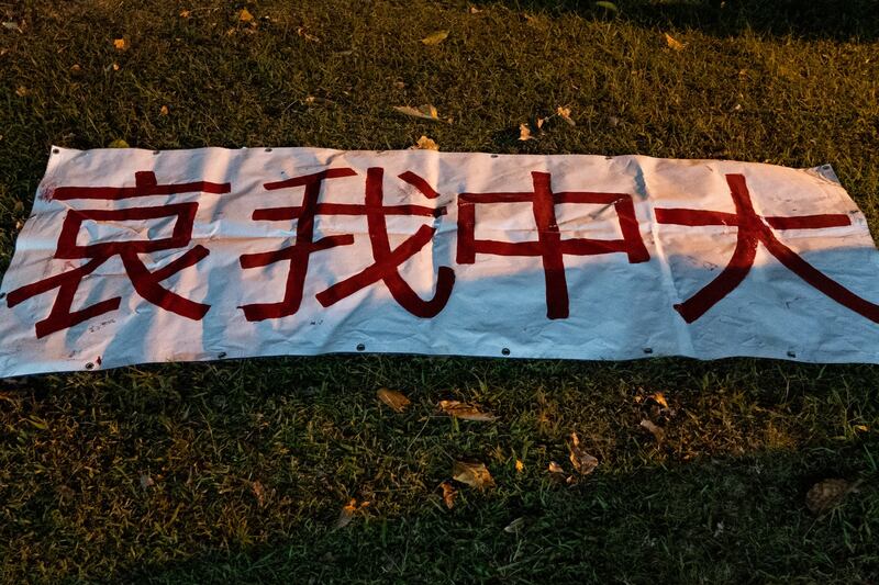 香港中文大学民主女神像被拆后，中大师生在女神像原址空地上放下鲜花、点上烛光悼念。(AFP)