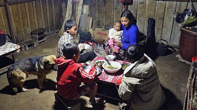 An ethnic Kachin family displaced by armed conflict has dinner at a temporary camp in northern Myanmar's Kachin state in an undated photo. Credit: RFA