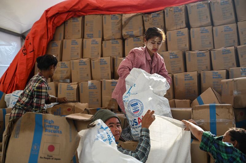 Workers sort through food at a damaged UN World Food Program warehouse in Sittwe in the aftermath of Cyclone Mocha's landfall. Myanmar's junta on Thursday issued a blanket ban on transportation for aid groups operating in Rakhine state only a day after State Government granting them permission to assist victims. Credit: Sai Aung Main/AFP