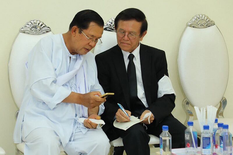 Former Cambodian opposition leader Kem Sokha (R) talking with Prime Minister Hun Sen (L) at a ceremony mourning Sen's mother in law in Phnom Penh, in a handout photo taken and released by Fresh News, May 5, 2020. Credit: AFP