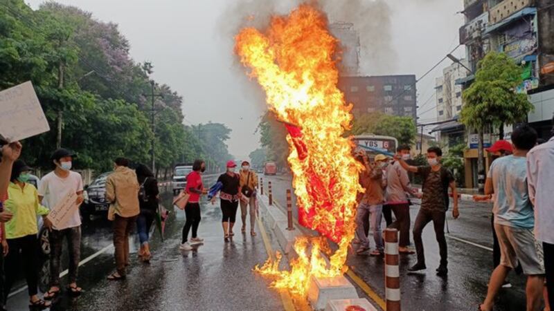 缅甸示威者焚烧中国国旗，对中国支持缅甸军政府表示不满。（路透社）