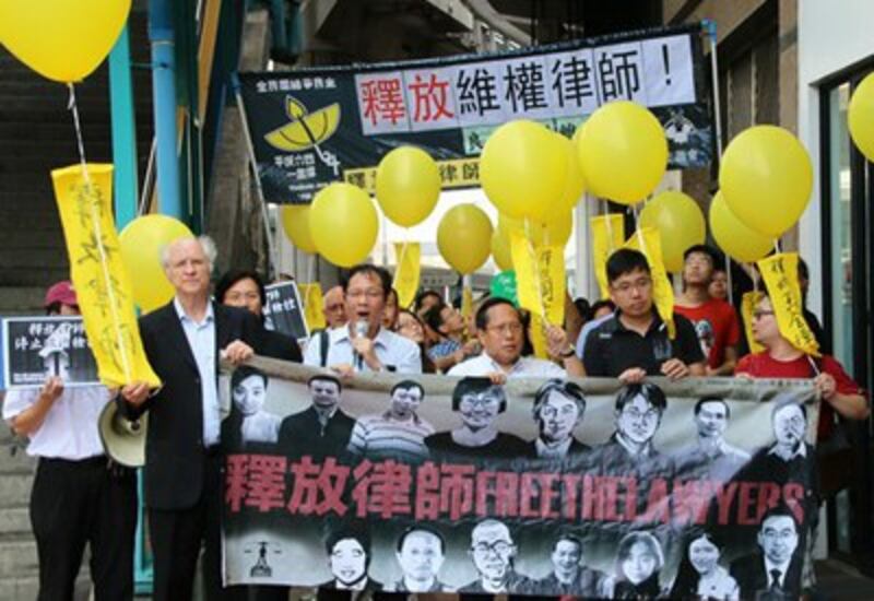 Hong Kong activists holding yellow balloons call for the release of lawyers jailed in mainland China, during a protest in Hong Kong, Oct. 9, 2015.