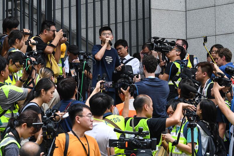 2019年6月21日，香港众志秘书长黄之锋（Joshua Wong）在警察总部外抗议时发表讲话，要求警务处处长卢伟聪撤回暴动定性，释放被捕人士。（法新社）