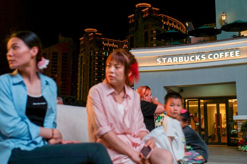 People sit outside a Starbucks coffee shop in Beijing, China, May 22, 2024. (Tingshu Wang/Reuters)