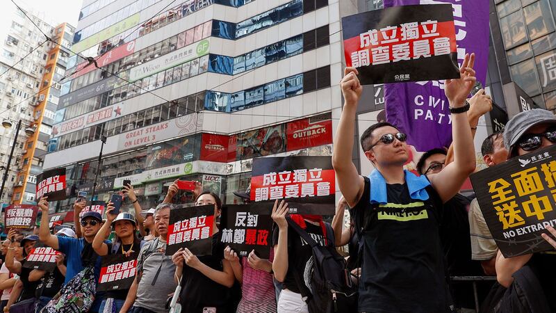 资料图片：2019年7月21日，香港反送中大游行时，示威者举着标语“成立独立调查委员会”。（美联社）