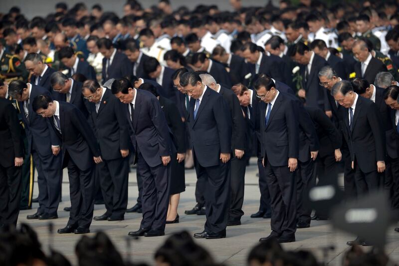 Chinese President Xi Jinping [center] and other officials bow during a ceremony to mark Martyr's Day at Tiananmen Square in Beijing, Sept. 30, 2019. (Mark Schiefelbein/AP)