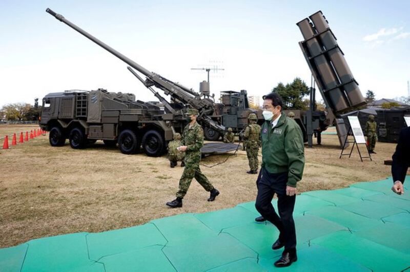 2021年11月27日，日本首相岸田文雄在日本陆上自卫队（JGSDF）朝霞驻屯地视察设备。左后方为19型155毫米轮式自走榴弹炮，右后方为12式地对舰导弹。(Kiyoshi Ota/Pool via REUTERS/File Photo)