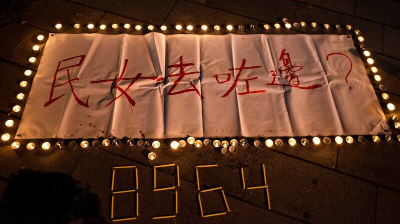 香港中文大学民主女神像被拆后，中大师生在女神像原址空地上放下鲜花、点上烛光悼念。(AFP)