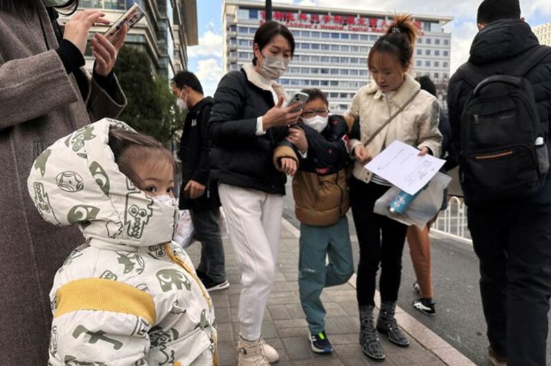 People and children leave a children's hospital in Beijing, China, Nov. 27, 2023. Credit: Tingshu Wang/Reuters