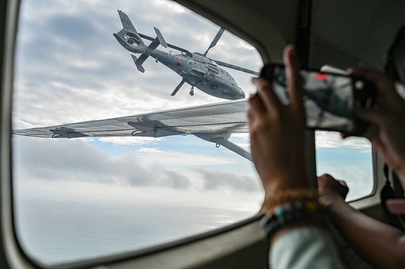 An aircraft identified by the Philippine Coast Guard as a Chinese Navy helicopter  flies near a Bureau of Fisheries and Aquatic Resources plane at Scarborough Shoal in the South China Sea on Feb. 18, 2025.