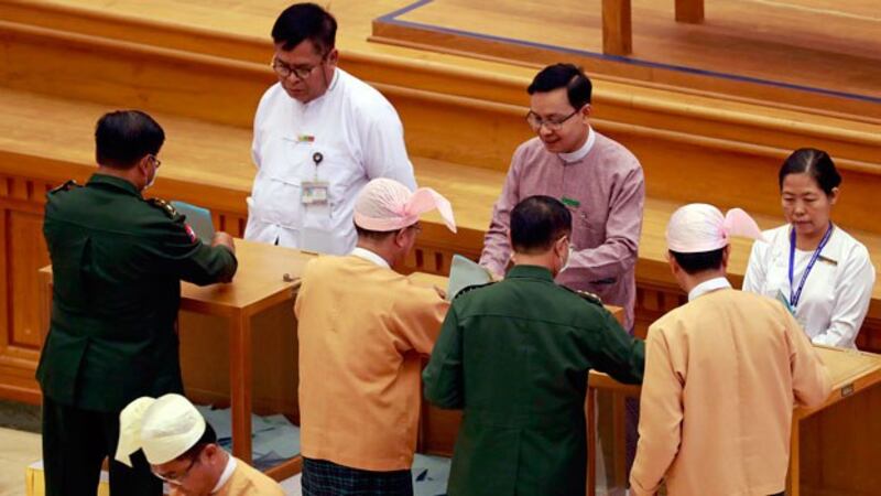 Lawmakers from the Myanmar military and the National League for Democracy party cast votes on bills to amend the 2008 constitution at the national parliament in Naypyidaw, March 10, 2020. 