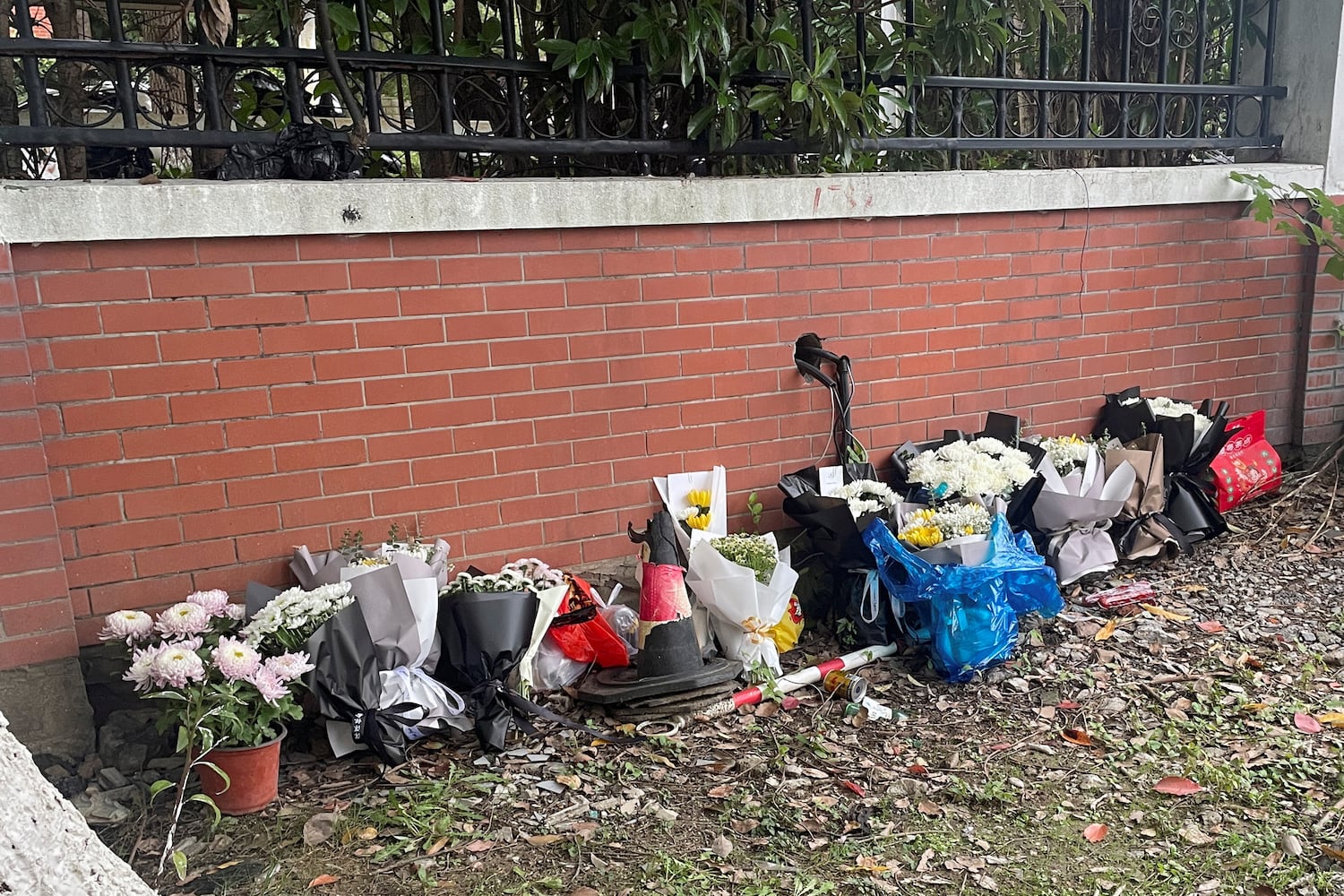 Floral tributes are placed near an entrance to the Wuxi Vocational College of Arts and Technology following a knife attack, in Wuxi, Jiangsu province, China Nov. 17, 2024. (Reuters/Brenda Goh)