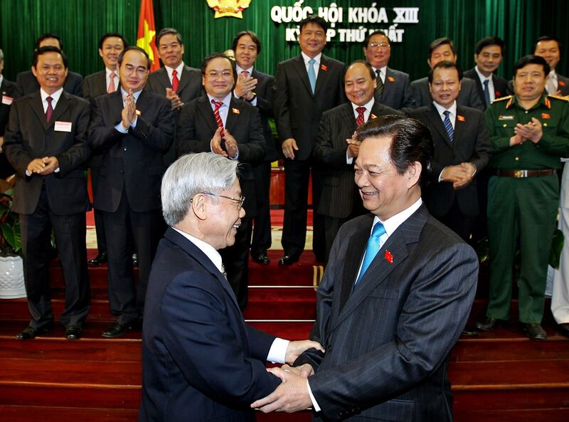 Nguyen Phu Trong, front left, chief of the Communist Party of Vietnam, shakes hands with Prime Minister Nguyen Tan Dung during the inauguration ceremony of the new cabinet in Hanoi, Aug. 3, 2011. (Nhan Sang/Xinhua via AP)