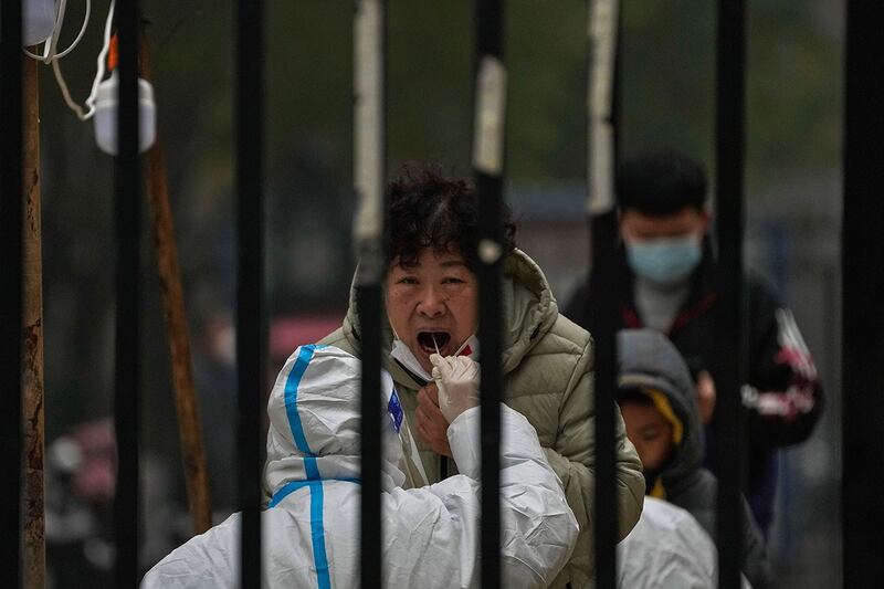 2022 年11月24日，一名妇女在北京一个住宅区内的病毒检测点进行常规检测。（美联社）