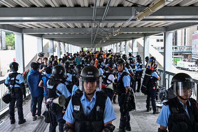 2019年6月13日，示威者在香港立法会外反《逃犯条例》，警察以暴力手段驱离示威民众后，警方在政府总部附近的天桥上守卫。（法新社）