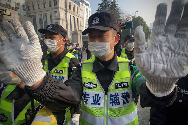 Police attempt to stop journalists from recording footage outside the Shanghai Pudong New District People's Court, where Chinese citizen journalist Zhang Zhan is set for trial in Shanghai, Dec. 28, 2020.