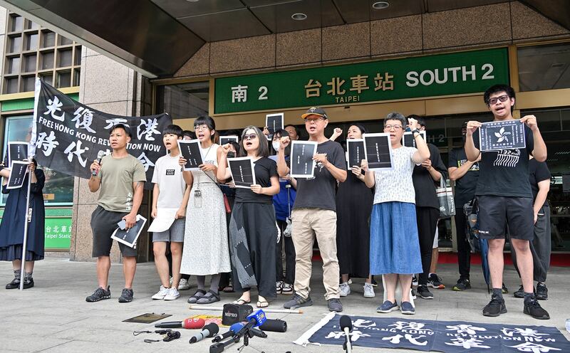 Dozens of people sing “Glory to Hong Kong” outside the main railway station in Taipei, Taiwan, on June 6, 2023, to mark the fourth anniversary of the start of the 2019 mass protest movement. Credit: Zhong Guangzheng