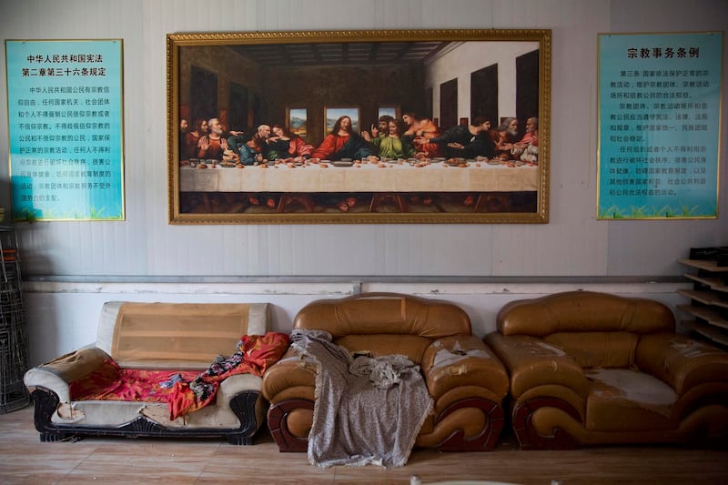 In this June 4, 2018 photo, a painting of the Last Supper is displayed next to posters quoting China's constitution on religious freedom in a house church shut down by authorities near the city of Nanyang in central China's Henan province. Credit: AP