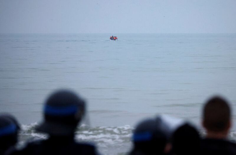 French police look on as a group of migrants on an inflatable dinghy leave the coast of northern France to cross the English Channel, in Wimereux near Calais, France, December 16, 2021. Credit: Reuters