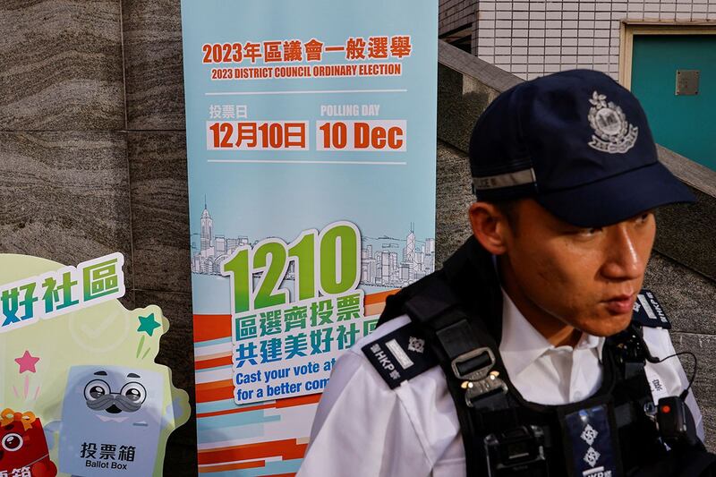 2023年12月10日，香港区议会选举期间，警察在投票站外守卫。（路透社）