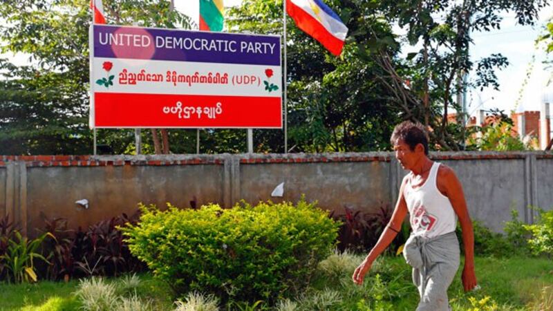 A man walks past a billboard of the United Democratic Party outside the party's headquarters in Myanmar's capital Naypyidaw, Sept. 30, 2020.