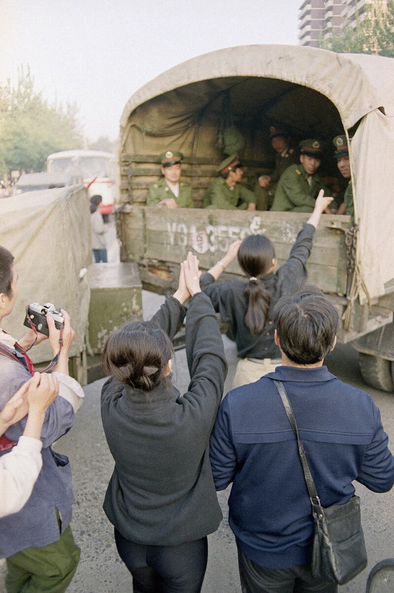 1989年5月20日，学生在戒严部队军人从北京市中心路障返回后向他们表示感谢。（美联社）