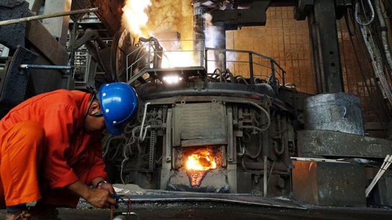 A Chinese steelworker works in front of a furnace at the Dalian Special Steel Company Ltd. in Dalian, northereastern China's Liaoning province, June 20, 2018. 