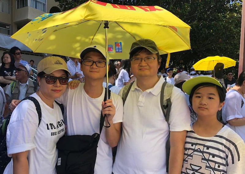 港人郭小峰一家四口打着2014年“占中”雨伞参加“反送中”集会（CK拍摄）