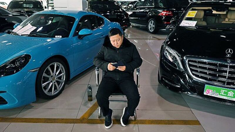 A sales representative waits for customers in a luxury car showroom in Beijing, Jan. 22, 2019.