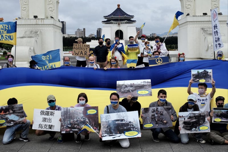 Slavic people living in Taiwan display posters and a Ukraine flag during a rally at the Free Square in front of the Chiang Kai-shek Memorial Hall in Taipei, May 8, 2022. Credit: AFP.