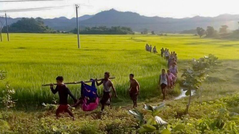 An elderly Rakhine man is carried by fellow villagers after he was injured by a landmine believed to be buried by the junta troops in a village in Kyauktaw, Rakhine state on Sept. 8, 2022. Credit: Citizen journalist