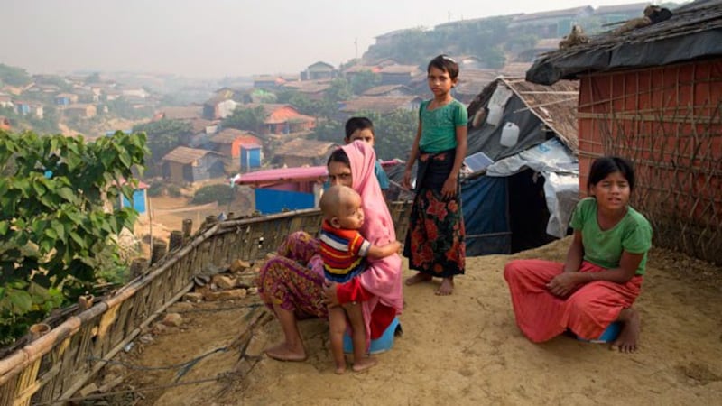 Rohingya refugee woman Anu (C) holds her son Mohammad Anas outside their shelter at the Balukhali refugee camp near Cox's Bazar in southeastern Bangladesh, Nov. 17, 2018.