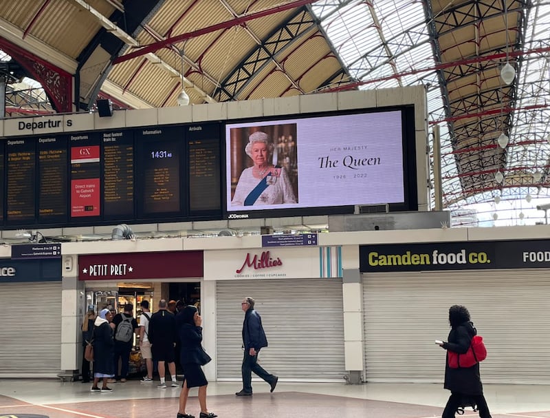 英女王伊丽莎白二世逝世，英国报章头版报道，火车站萤幕也换上女王肖像。 （吕熙摄）