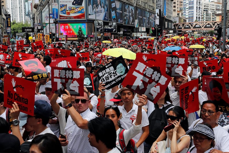 2019年6月9日，香港百万人游行反对特区政府修订《逃犯条例》，示威群众手持着“不要引渡”和““卖港林郑下台”等口号。（路透社）