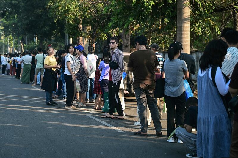 People stand in line to get visas at the Thai embassy in Yangon on Feb. 16, 2024 after Myanmar's military government said it would implement military conscription. (AFP)