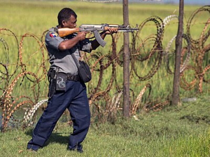 An armed Myanmar border policeman scans the border area along the river dividing Myanmar and Bangladesh in Maungni village, Maungdaw township, western Myanmar's Rakhine state, Oct. 15, 2016.