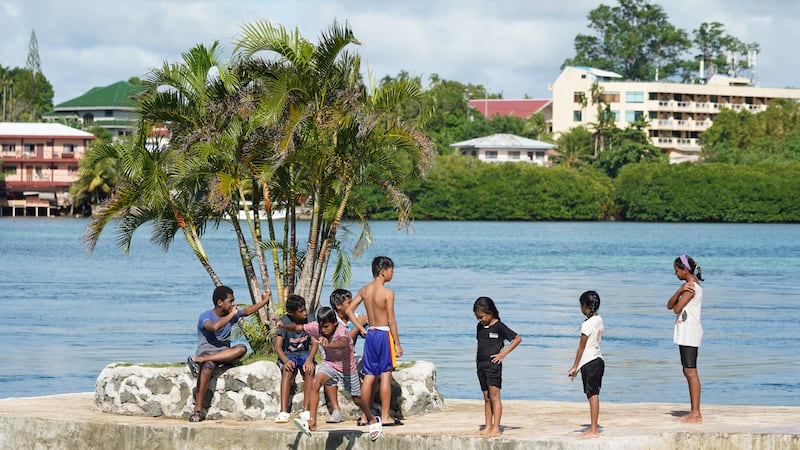 A group of children play near the ocean in Koror, Nov. 29, 2024.