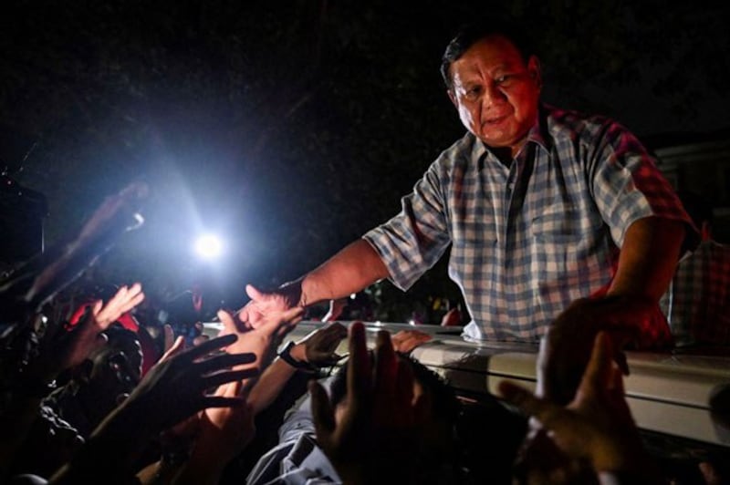 Indonesian Defense Minister and presidential candidate Prabowo Subianto greets supporters from a car in Jakarta, Feb. 14, 2024. (Antara Foto/Erlangga Bregas Prakoso via Reuters)