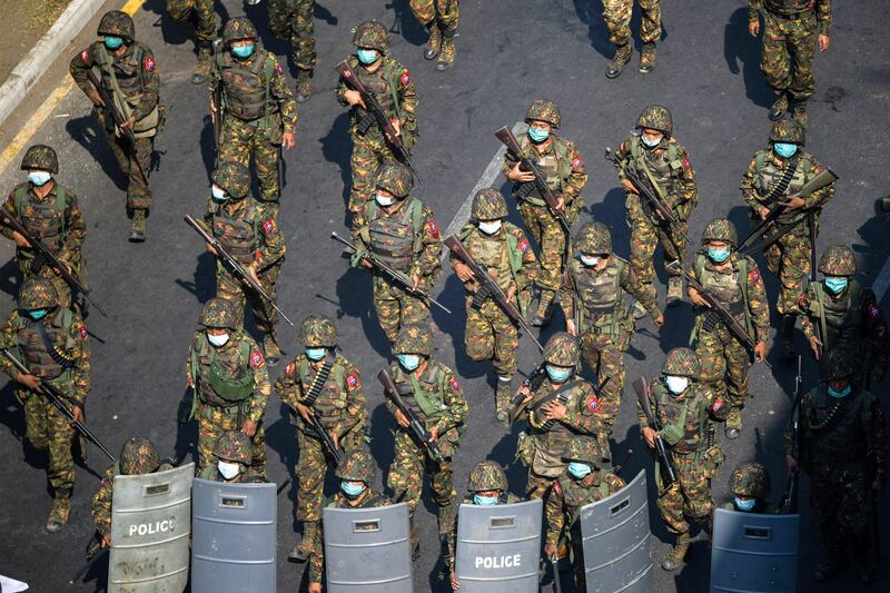 Myanmar soldiers walk down a street during a protest against the military coup in Yangon, Feb. 28, 2021. Credit: Reuters