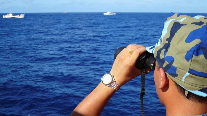 A crewman from the Vietnamese coastguard ship looks out at sea as Chinese coastguard vessels give chase to Vietnamese ships near an oil rig in the South China Sea in a file photo from July 2014. 