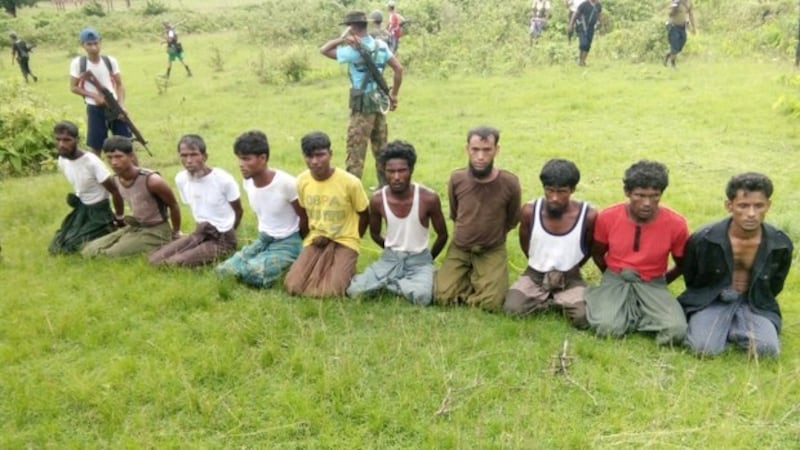 Ten Rohingya men with their hands bound kneel as members of the Myanmar security forces stand guard in Inn Din village of Rakhine State, Myanmar, Sept. 2, 2017. Credit: Reuters