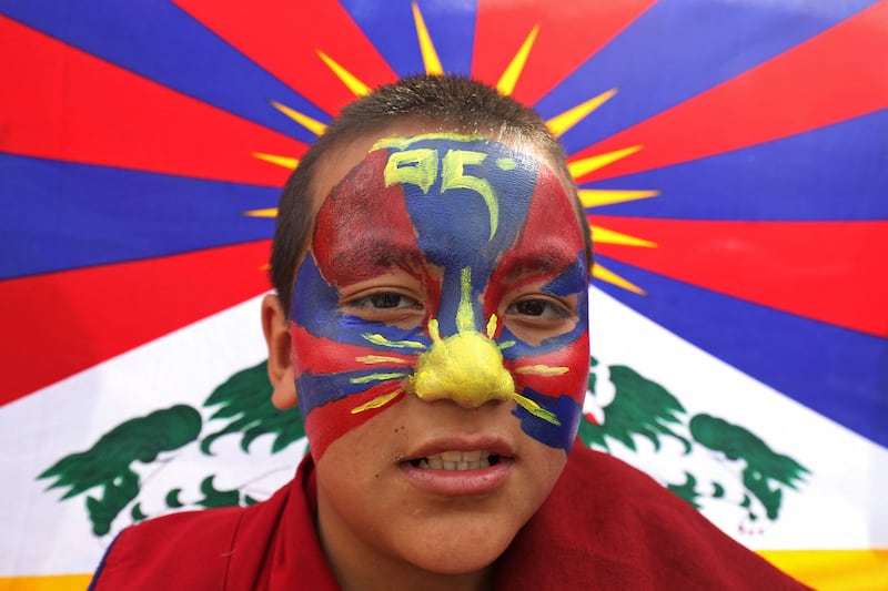 A Tibetan youth with his face painted in the colors of the Tibetan flag attends a peace march during the 65th Tibetan National Uprising Day against the Chinese occupation of Tibet, in the suburb of McLeod Ganj near Dharamsala on March 10, 2024. Tibetans in exile in India on March 10 waved the flag of their homeland in protests marking 65 years since a failed uprising was crushed by Chinese troops, driving the Dalai Lama and thousand of compatriots to flee.