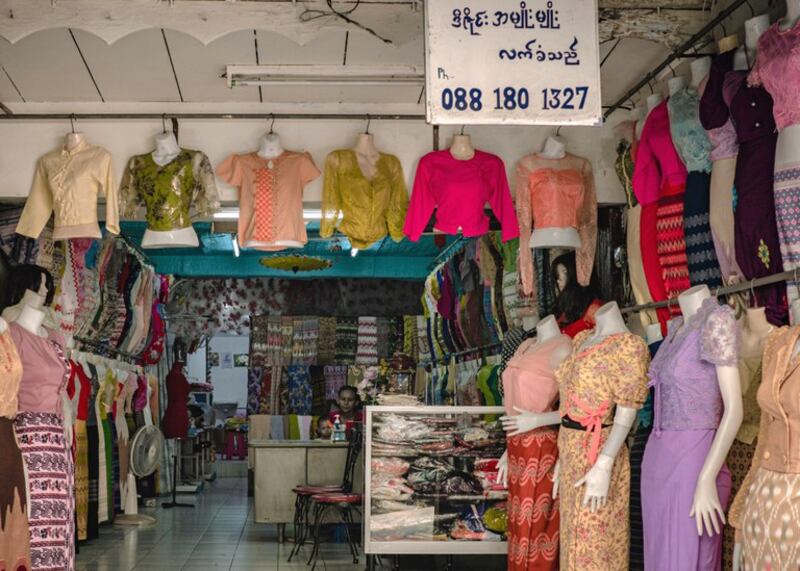 A Burmese-language sign hangs in a clothing store operated by Yi Win, a Myanmar man who immigrated shortly before the February 2021 coup, in his shop in the Phra Khanong section of Bangkok, March 13, 2024. (Wissarut Verasopon/Thai News Pix/BenarNews)