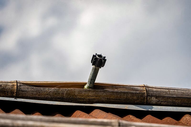 An unexploded projectile juts from the roof of a house following fighting between Myanmar's military and the Kachin Independence Army in Nam Hpat Kar, Kutkai township in Myanmar's northern Shan State, Feb. 4, 2024. (AFP)