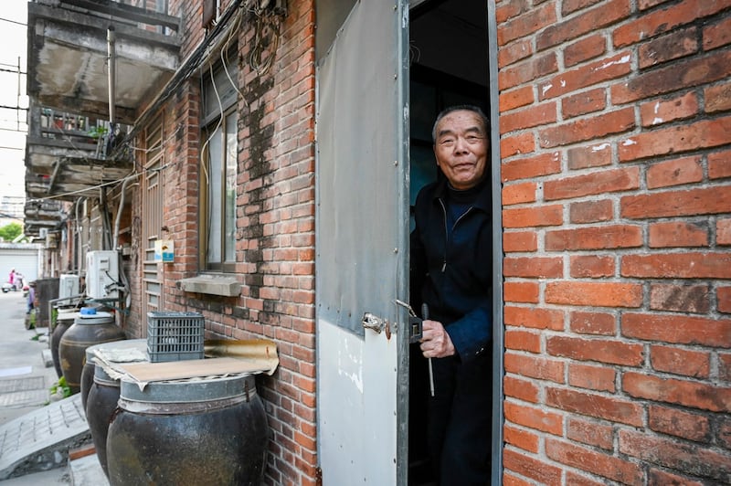 An elderly man opens a door in a residential area in Rudong, in eastern Chinaís Jiangsu province, April 27, 2023. (Jade Gao/AFP)