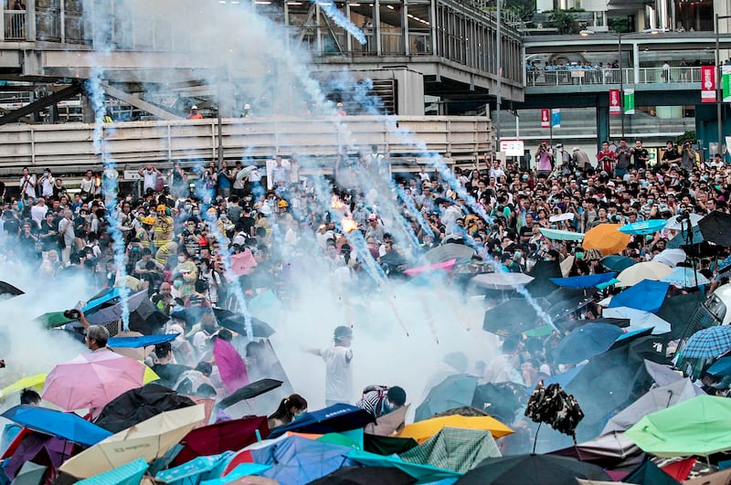 Riot police launch tear gas into the crowd as thousands of protesters surround the government headquarters in Hong Kong, Sept. 28, 2014. Credit: AP Photo