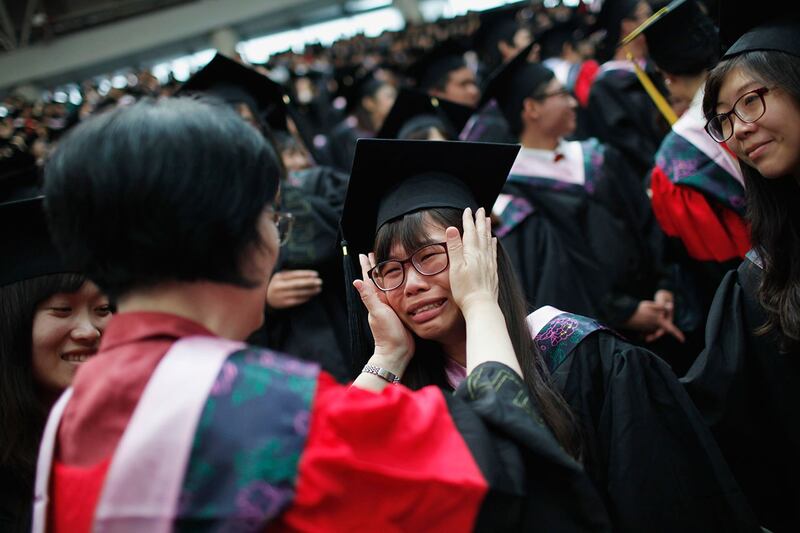 2013年6月28日，上海复旦大学的一名老师在毕业典礼上安慰哭泣的毕业生。（路透社资料图片）