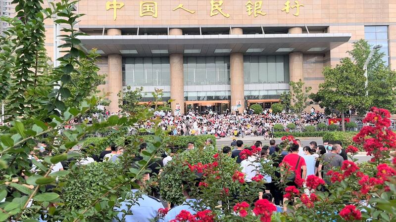 2022年7月10日，示威者在中国人民银行郑州支行大楼外抗议农村银行冻结存款。（路透社图片）