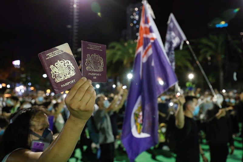 2020 年 6 月 4 日，一名香港示威者手举英国国民海外护照(BNO)。（路透社）